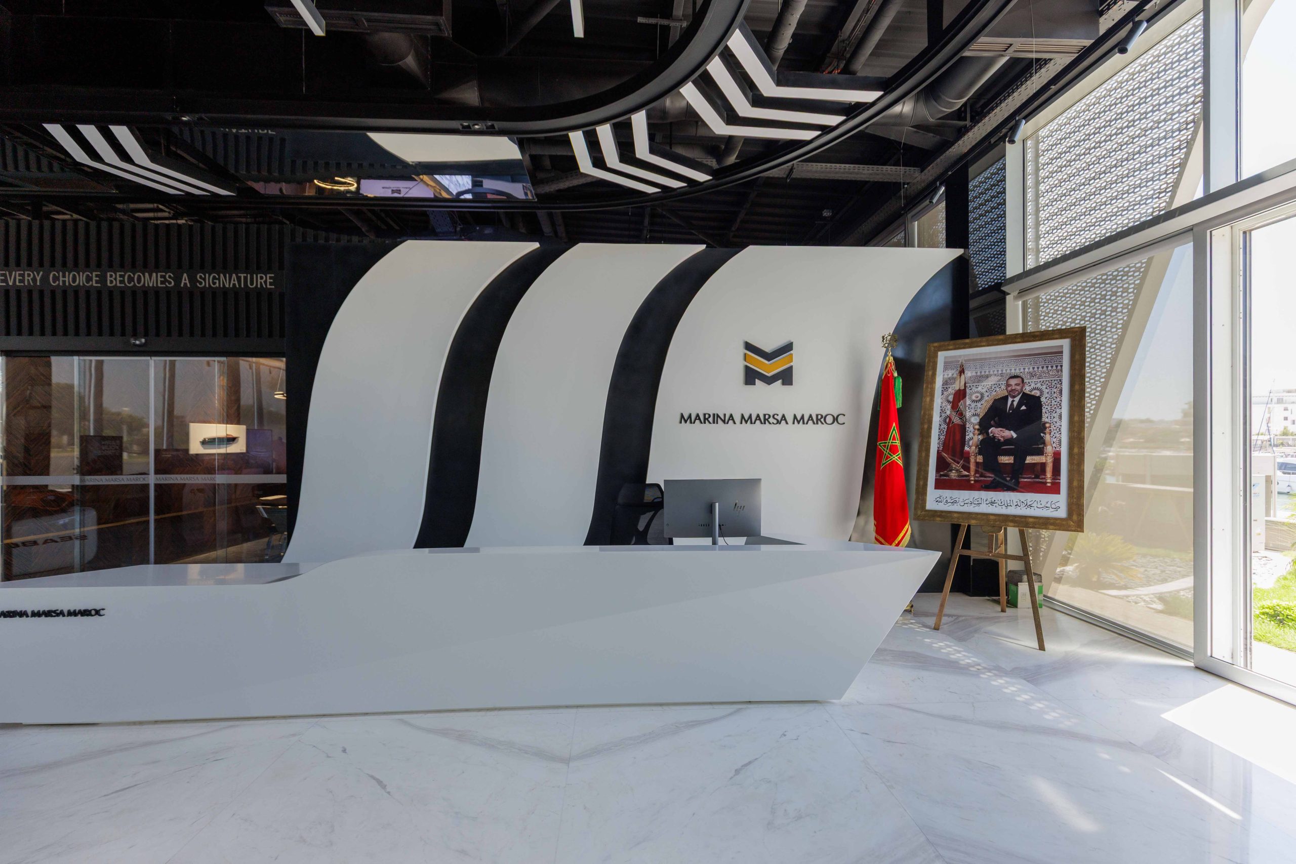 Reception desk at the Marina Marsa Maroc showroom, beneath the motto Every Choice Becomes a Signature