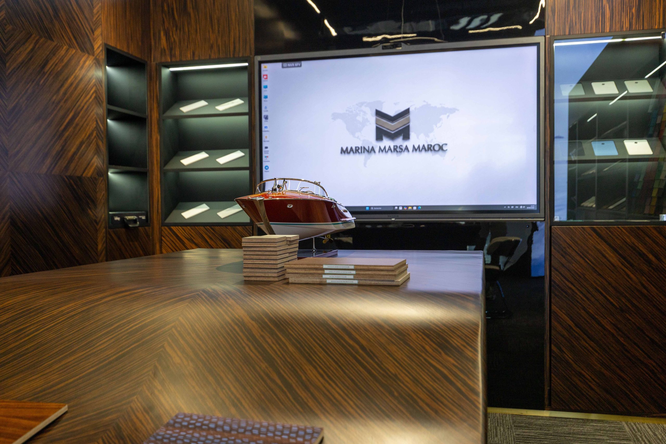 Client consultation table with a Riva model yacht and material finish swatches