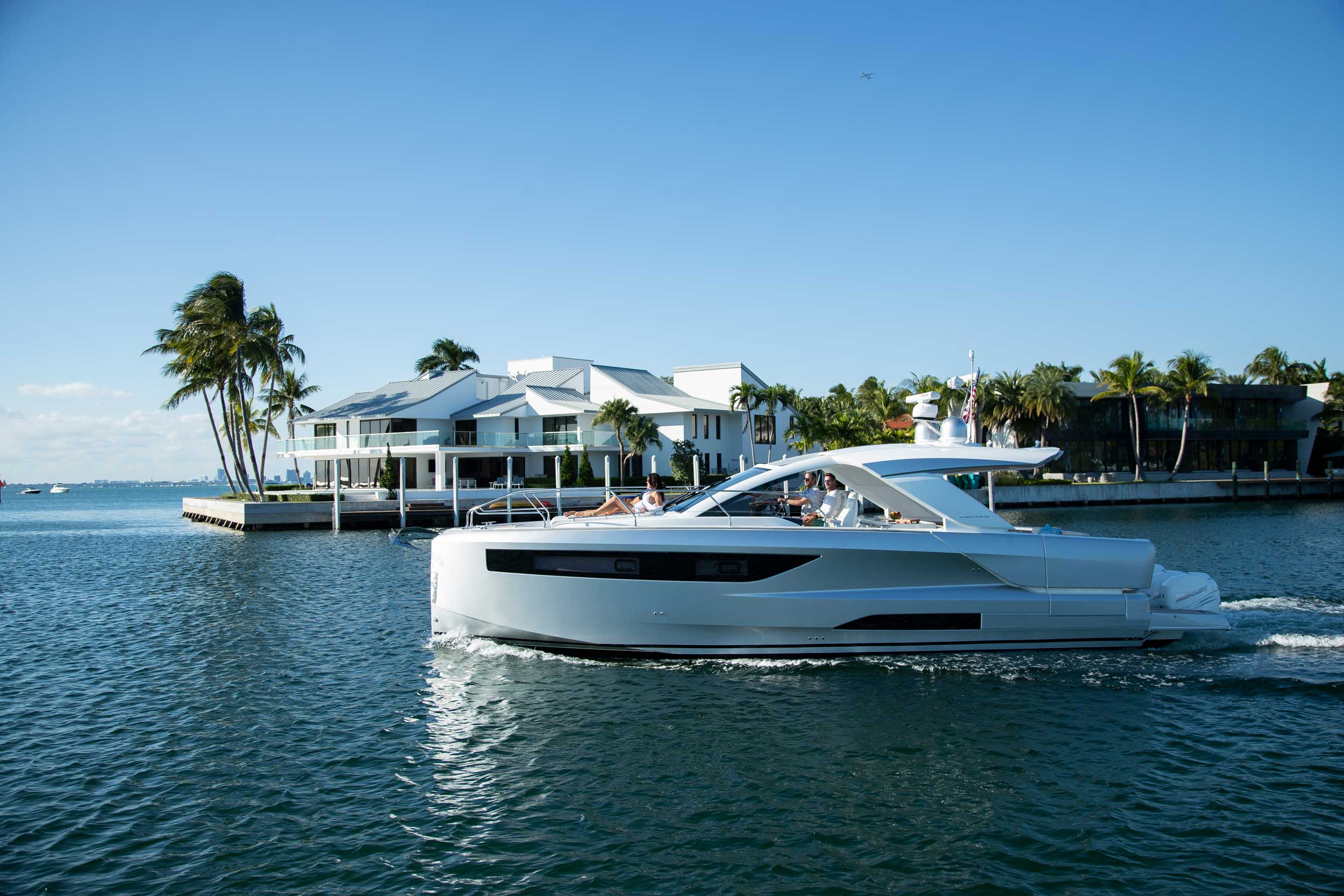 Jeanneau DB/43 OB cruising past waterfront homes